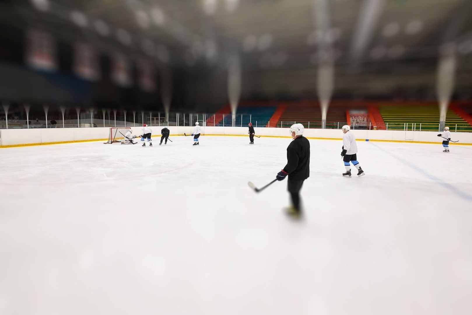 Hockeyspelare tränar passningar på en inomhusis med klubbor
